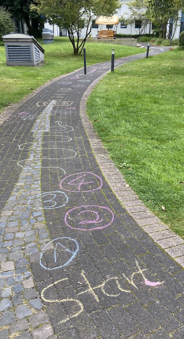 Chalk markings by kids on the walkways in the garden around the hotel. You can see the word "Start" and circles with consecutive numbers snaking away from it